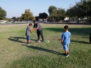 SBCUSD high school student helping younger elementary school students learn the golf swing.